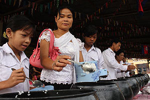 A family at Phnom Penh’s Wat Ang Pothinhean fill monks’ bowls with rice on Monday, the first day of the15-day celebration of P’Chum Ben.