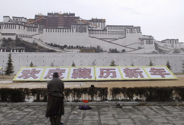 Un Tibétain prie devant le palais du Potala, à Lhassa, le 25 février 2009. Aujourd'hui, tous les panneaux et inscriptions sont écrits en chinois.