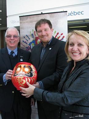 Jean-Claude Montplaisir, donneur de la campagne de financement, Jean-François Royal, directeur général du Musée des religions et Liette Girard, présidente d'honneur de la campagne de financement, présentent un Daruma, une figurine traditionnelle japonaise, dont la vente servira à recueillir des fonds pour l'institution.