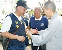 buddhist from Tzu Chi Foundation handing a gift to the police man who fights the disaster
