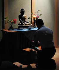 Steve Honda, an Air Force Academy military trainer, kneels before the altar in the base's Buddhist chapel.
