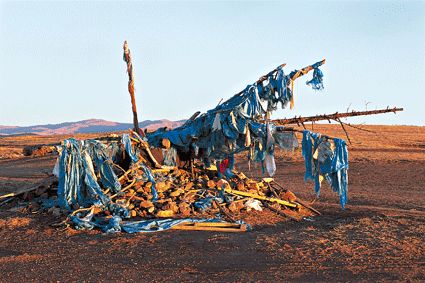 Un ovoo près d’Erdenet (province de Bulgan), point de convergence des pistes et des croyances. L’empilement rituel d’offrandes disparates (pierres, billets de banque, pneus, bouteilles, conserves) marque la résidence de l’esprit du lieu.