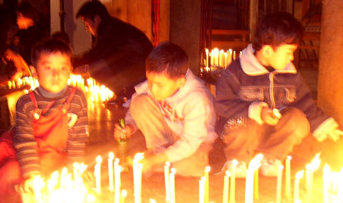 Tibetan children in Delhi lighting candles