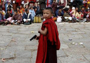 Buddhist monk with toy gun. Bhutan, 2008.