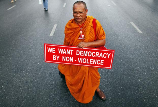 A Buddhist monk holds a banner as he joins other supporters of former premier Thaksin Shinawatra in central Bangkok. Anti-government protesters headed for Bangkok from the countryside on Saturday for what they are calling a 