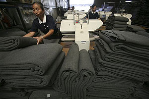 In this image made on Sept. 7, 2010, a volunteer folds blankets made from recycled plastic bottles at The Tzu Chi Foundation factory in Taipei, Taiwan. The Tzu Chi Foundation, known for performing good works to those in need, dispatched thousands of the eco-blankets to survivors of this year's massive earthquake in Haiti and soon will be shipping more to flood survivors in Pakistan.