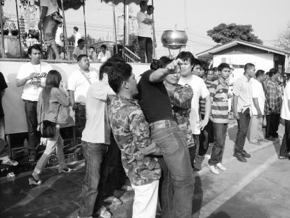 Des gardes maitrisent un homme en transe tentant de s'approcher e la statue de Luang Phor Phern