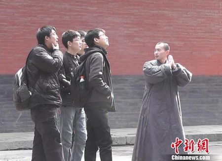 Un moine exerce comme guide gratuit pour les touristes au Temple de Shaolin.