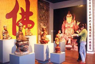 Visitors contemplate Buddhist statues on display in the Ha Noi-based National Museum of History. The exhibition will last until August this year.