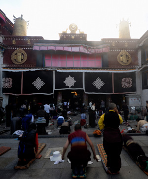People pray in front of a figure of buddha at Jokhang Temple in Lhasa, southwest China's Tibet Autonomous Region, while celebrating the peak day of the Sakadawa Festival