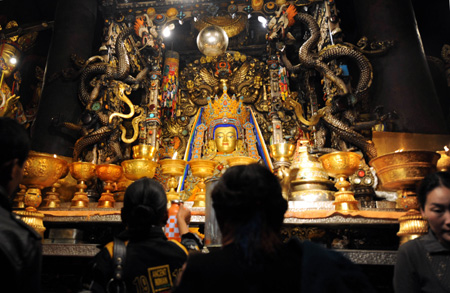 People pray in front of Jokhang Temple in Lhasa, southwest China's Tibet Autonomous Region, while celebrating the peak day of the Sakadawa Festival