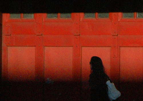 Woman walking by a red door