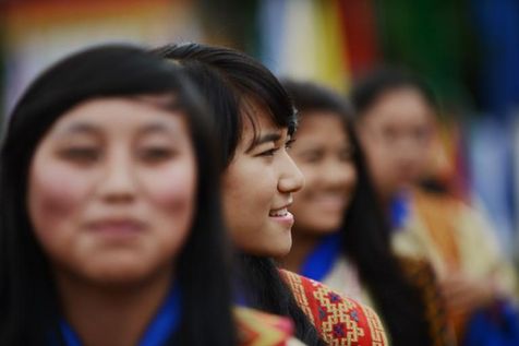 Des jeunes filles du Bhoutan sourient en interprétant une danse traditionnelle, le 2 juin 2013 à Thimphou (Photo Roberto Schmidt. AFP)