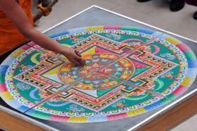 Richard Burkhart/Savannah Morning News A monk carefully begins the process of deconstructing the sand mandala, which was created during the week by Tibetan Buddhist monks of Drepung Loseling Monastery during a special closing ceremony Sunday afternoon at the Jepson Center.