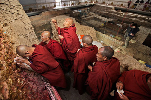 Monaci in pellegrinaggio al tempio di Lumbini. Sullo sfondo gli scavi archeologici che interessano l'area