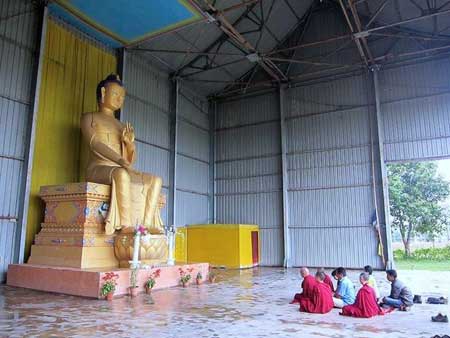 Lama Zopa Rinpoché en prière devant la statue de 7m50 du Bouddha Maitréya à Bodhgaya