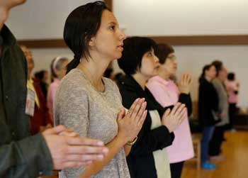 Carolina Ramos, second from left, prays during an Earth Day ceremony at the Fo Guang Shan Temple on Sunday in Raleigh. JILL KNIGHT