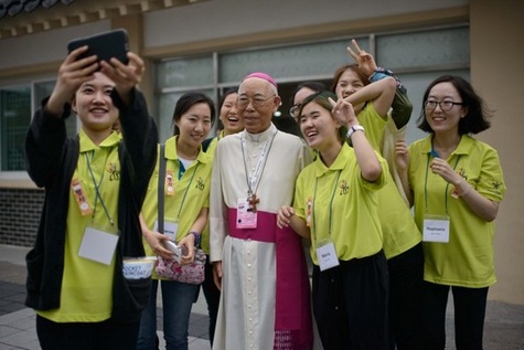 Des volontaires se prennent en photo avec un évêque sud-coréen, pendant le voyage du pape en Corée du Sud, le 17 août 2014 à Haemi.