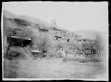 Vue extérieure des grottes 1 à 40 par Charles Nouette. Chine, province du Gansu, Dunhuang, grotte aux manuscrits, entre le 25 février et le 27 mai 1908. Epreuve à la gélatine sur papier.
