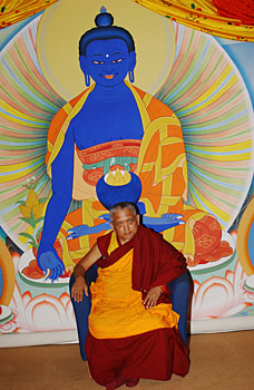 Lama Zopa Rinpoché devant une tangkha du Bouddha de la Médecine.